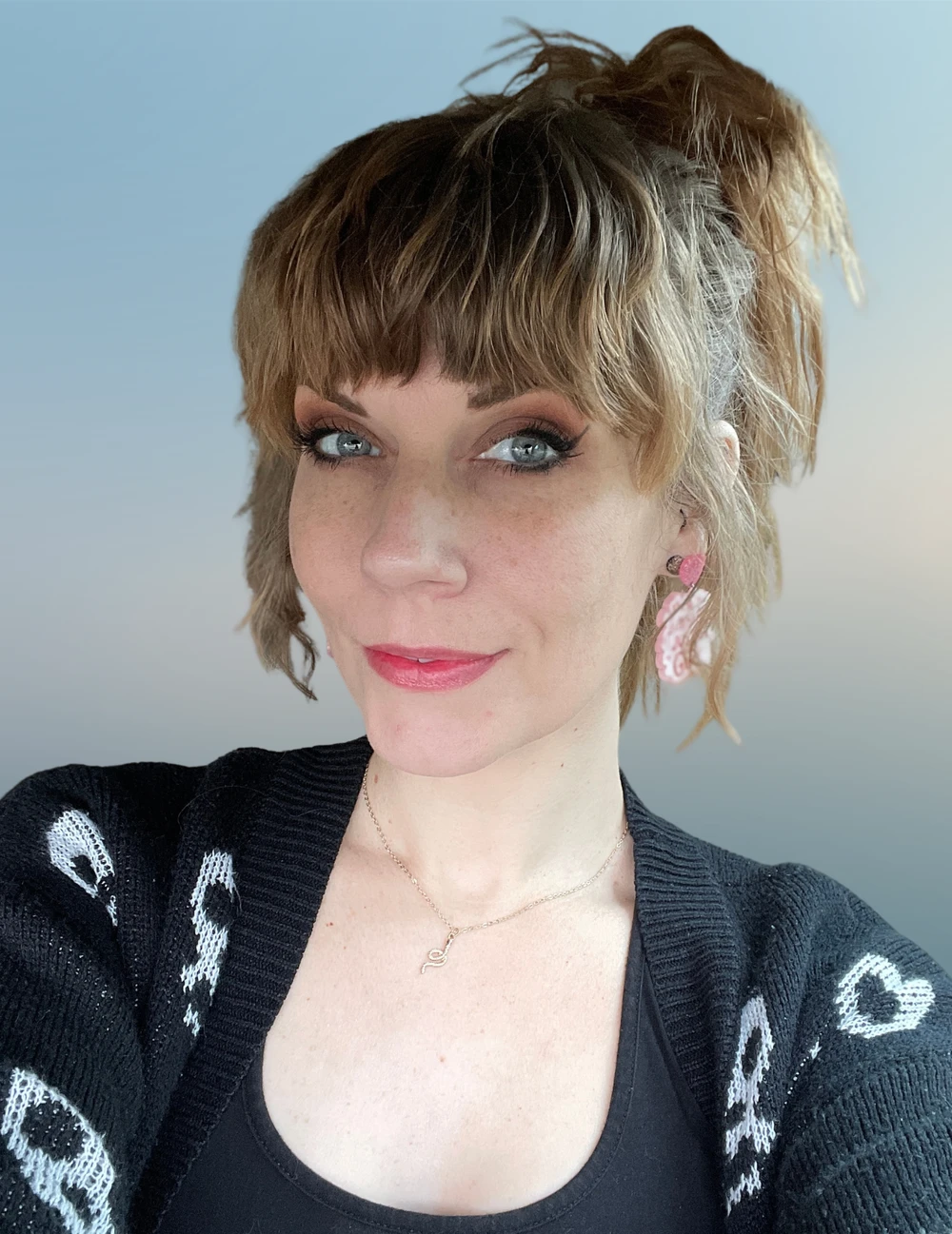 Jenn Pacek wearing a black sweater and a serpent necklace